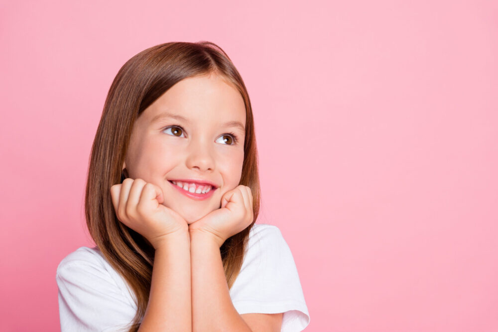 Child smiling after getting her ears pierced at MDtouch.ca